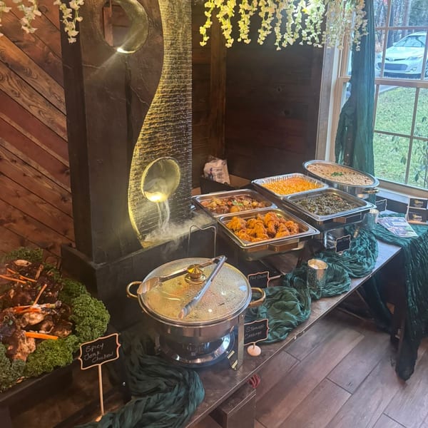 A Jamaican buffet with spicy jerk chicken, fry chicken, steamed cabbage, and other dishes.