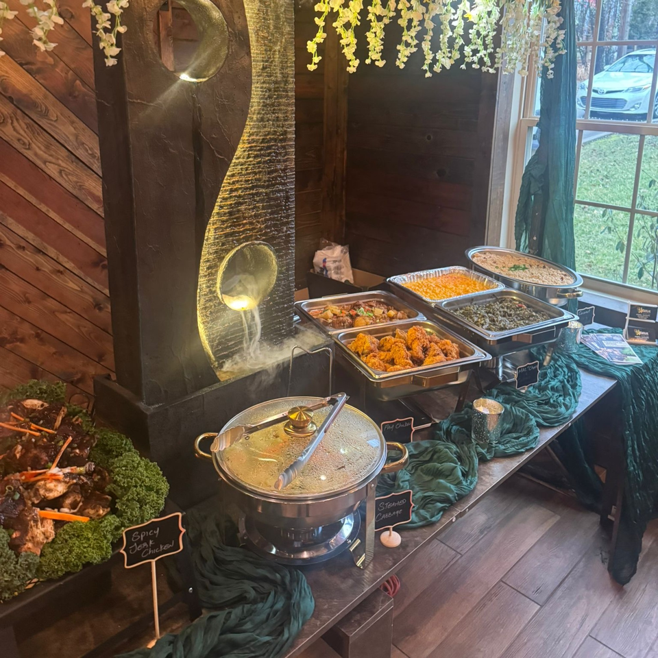A Jamaican buffet with spicy jerk chicken, fry chicken, steamed cabbage, and other dishes.
